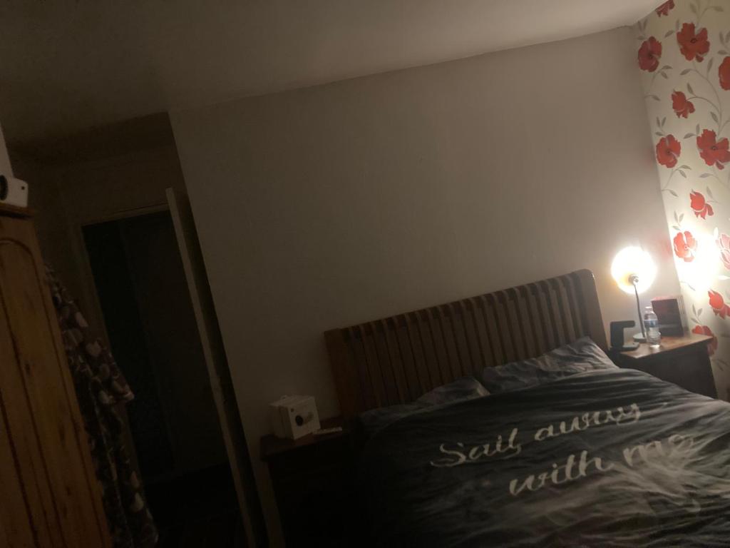 um quarto com uma cama e um candeeiro sobre uma mesa em Guest House Chelsea em Halewood