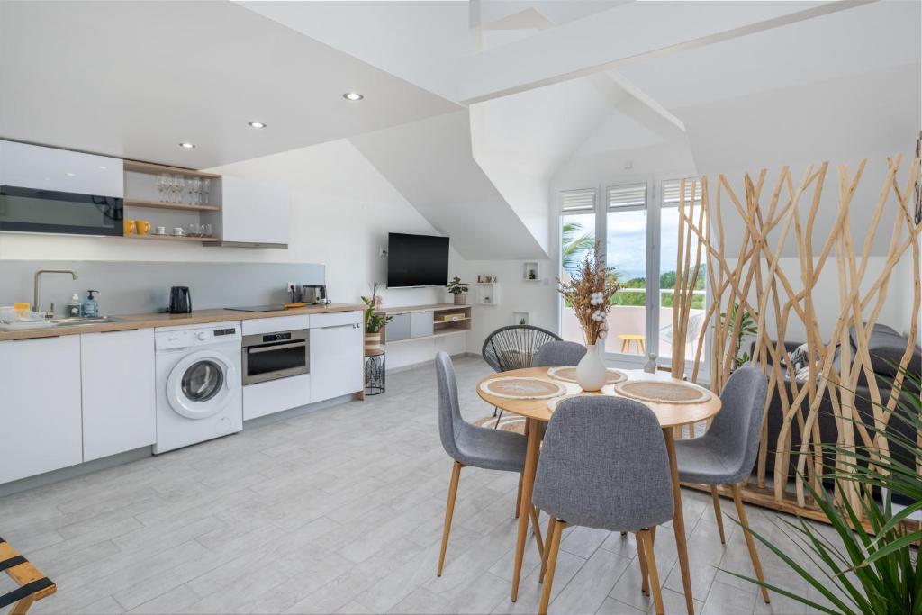a kitchen and living room with a table and chairs at Studio Mare Gaillard in Le Gosier