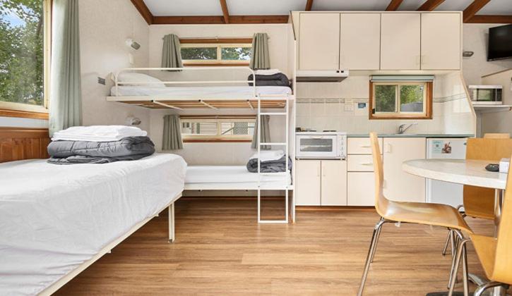 金逹拜恩的住宿－金德拜恩NRMA假日公園，小房间设有两张双层床和一张桌子