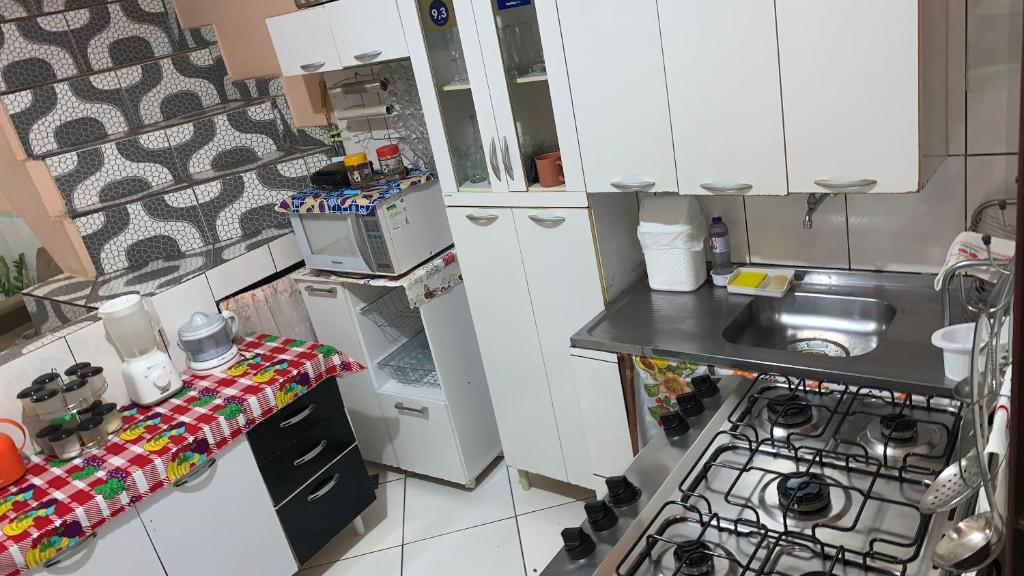 a small kitchen with a sink and a stove at Pousada Da Lú in Lençóis