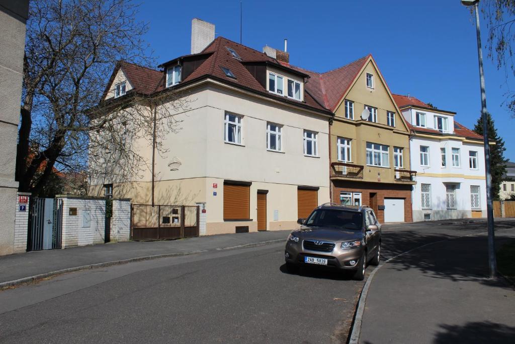 a car parked on the street in front of a building at Pension Hanspaulka in Prague