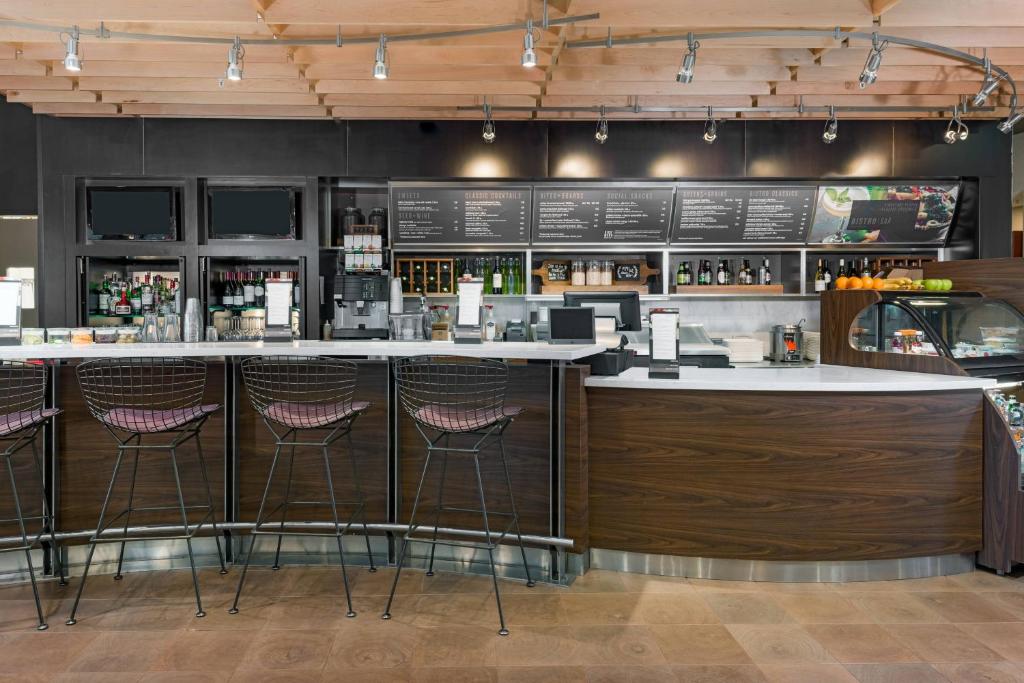 a bar in a restaurant with stools at Courtyard by Marriott Buffalo Airport in Cheektowaga
