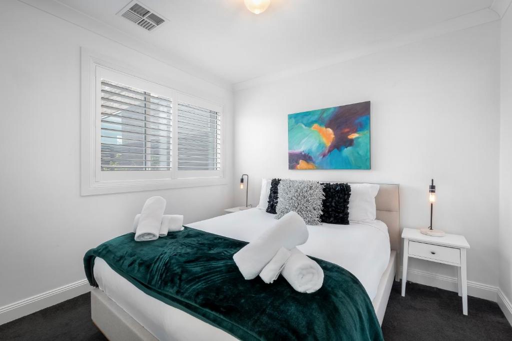una camera da letto con un letto con lenzuola bianche e una finestra di Brisbane Terrace - 3 Bedroom Hobart Inner City - Free Parking a Hobart