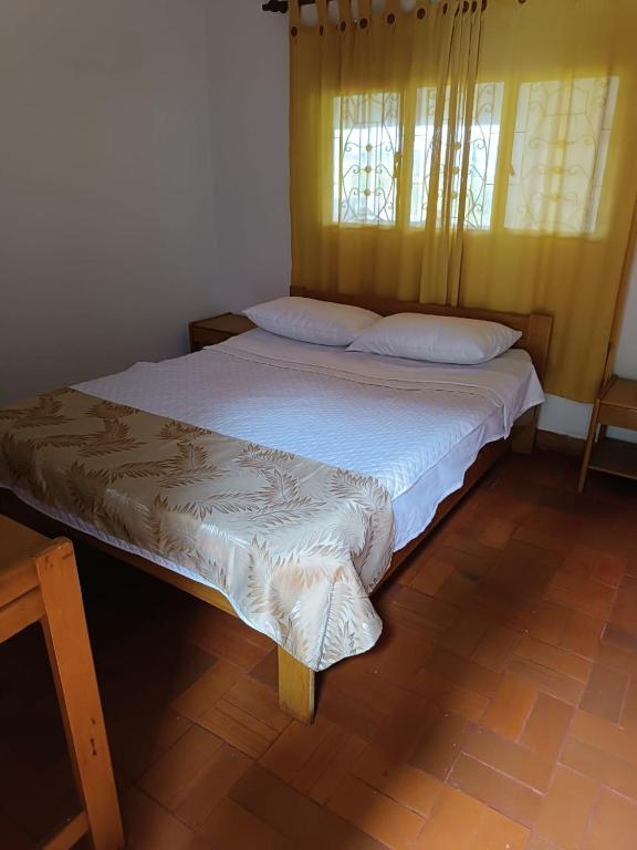 a bedroom with a large bed with white sheets and a window at Finca villa sofia in Albán