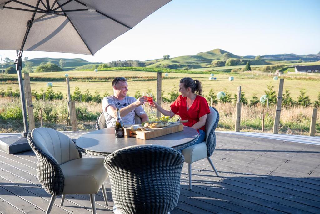 een man en vrouw die aan een tafel wijn drinken bij Holiday Bliss - Kiwi Suite in Tirau