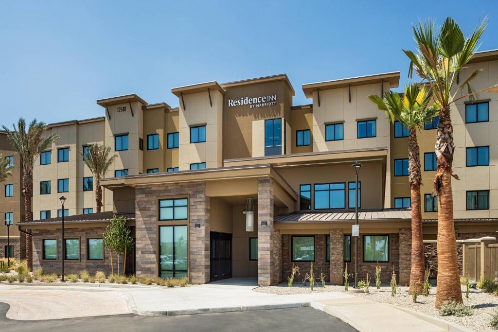 a building with palm trees in front of it at Residence Inn Riverside Moreno Valley in Moreno Valley