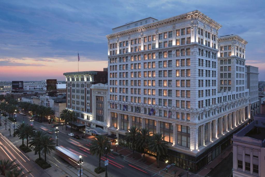 - un grand bâtiment blanc dans une rue de la ville la nuit dans l'établissement The Ritz-Carlton, New Orleans, à La Nouvelle-Orléans