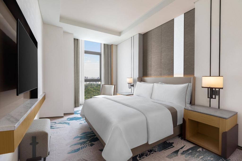 a hotel room with a bed and a television at The Westin Manila in Manila