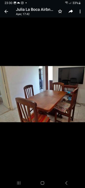 stół jadalny z 2 krzesłami i telewizor w obiekcie Departamento en la Boca piso 11 vista panoramica w BuenosAires