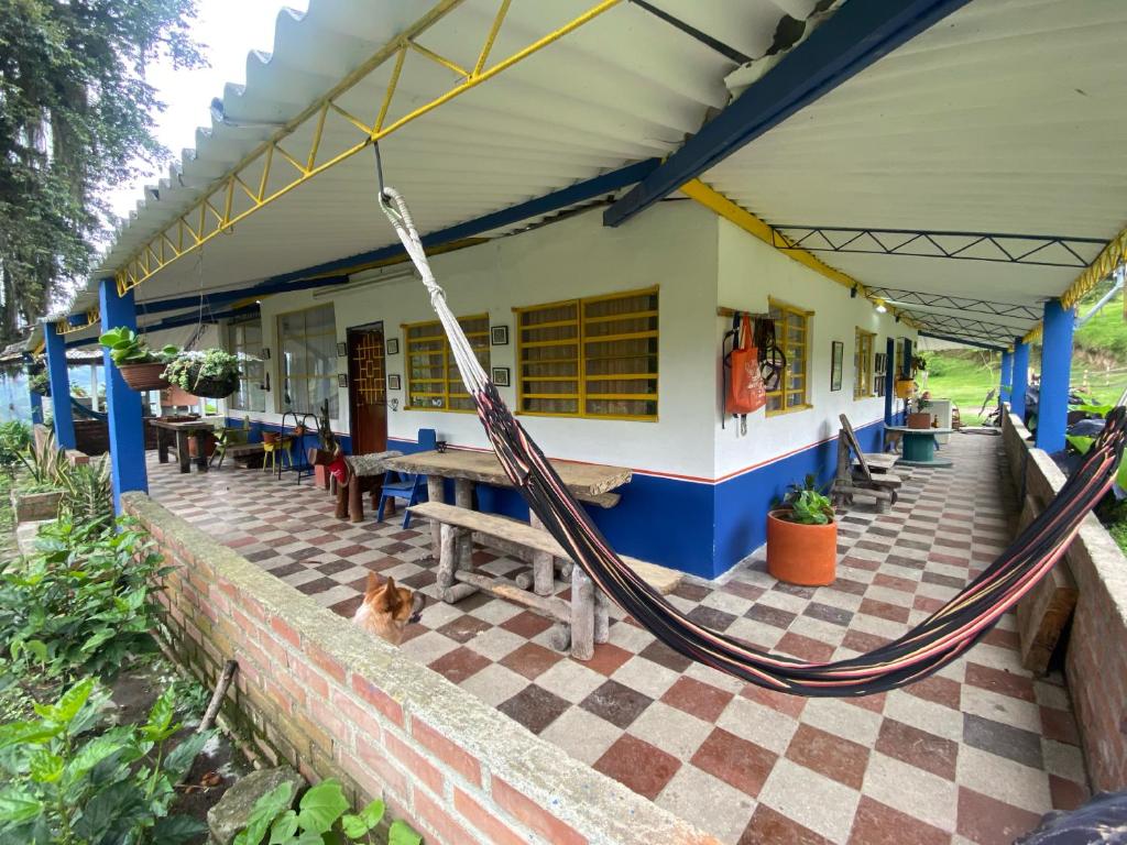 a porch with a hammock outside of a building at Hostal Las Hamacas del Bosque in Villamaría