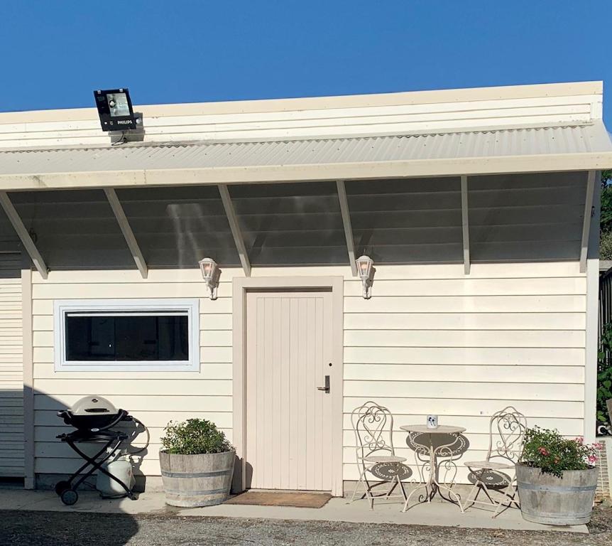 un garage avec une table et des chaises devant lui dans l'établissement BENROSE FARM COTTAGES, à Wellington