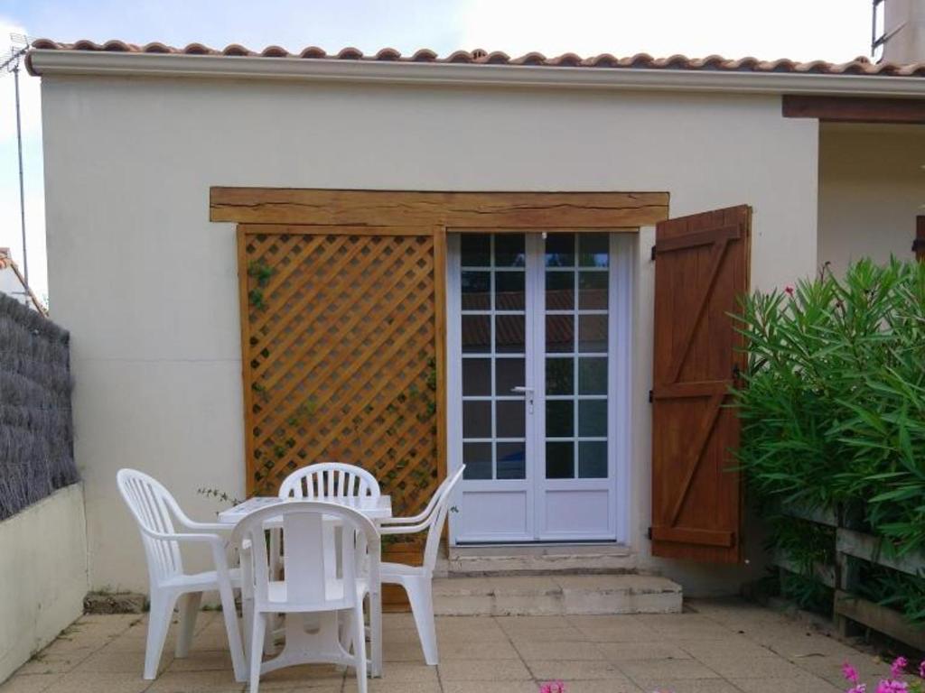 patio con mesa, sillas y puerta en Maison Notre-Dame-de-Monts, 3 pièces, 4 personnes - FR-1-540-249, en Notre-Dame-de-Monts