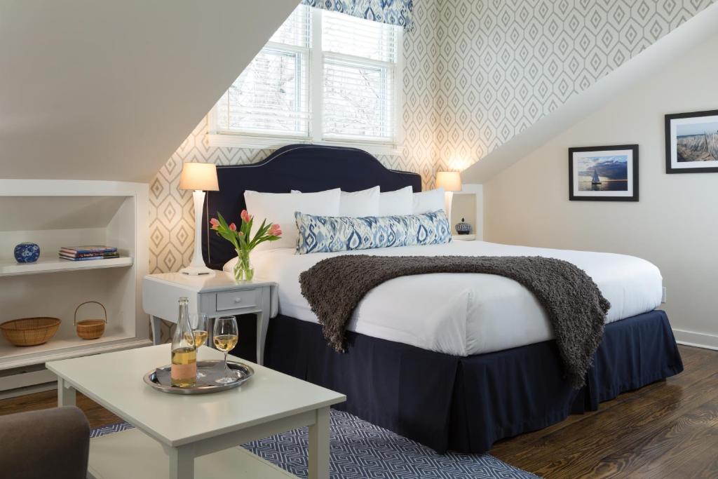 um quarto com uma cama king-size e uma mesa em Brass Lantern Inn em Nantucket