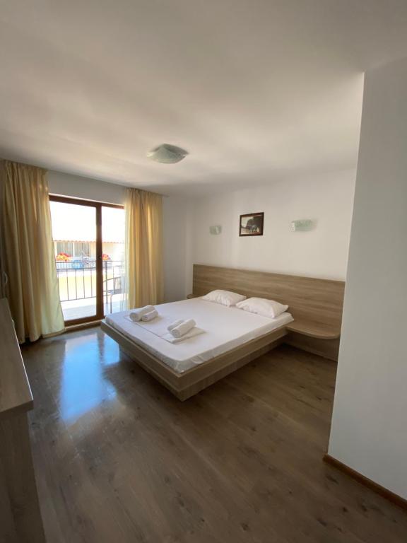 a bedroom with a bed and a large window at Vila Dedy in Costinesti