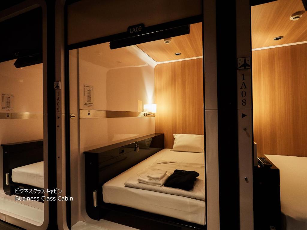 Postel nebo postele na pokoji v ubytování First Cabin Nishi Umeda