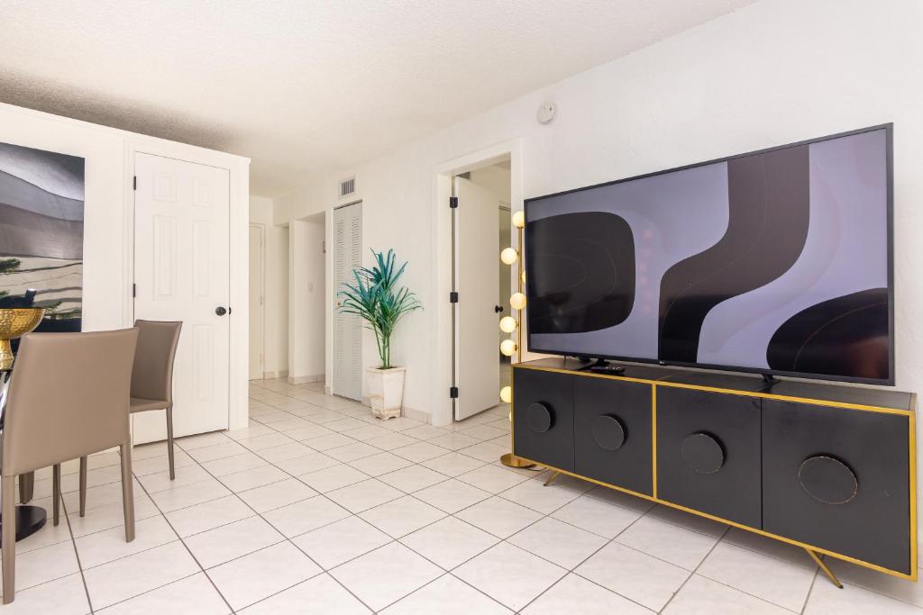 - un salon avec une grande télévision à écran plat dans l'établissement Two Bedroom Apartment - with Parking & Balcony - Heart of Wynwood, à Miami