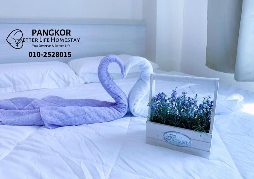 eine Schachtel mit einem Schwan und Blumen auf einem Bett in der Unterkunft Better Life Apartment near beach-2room 2bathroom 6pax in Pulau Pangkor