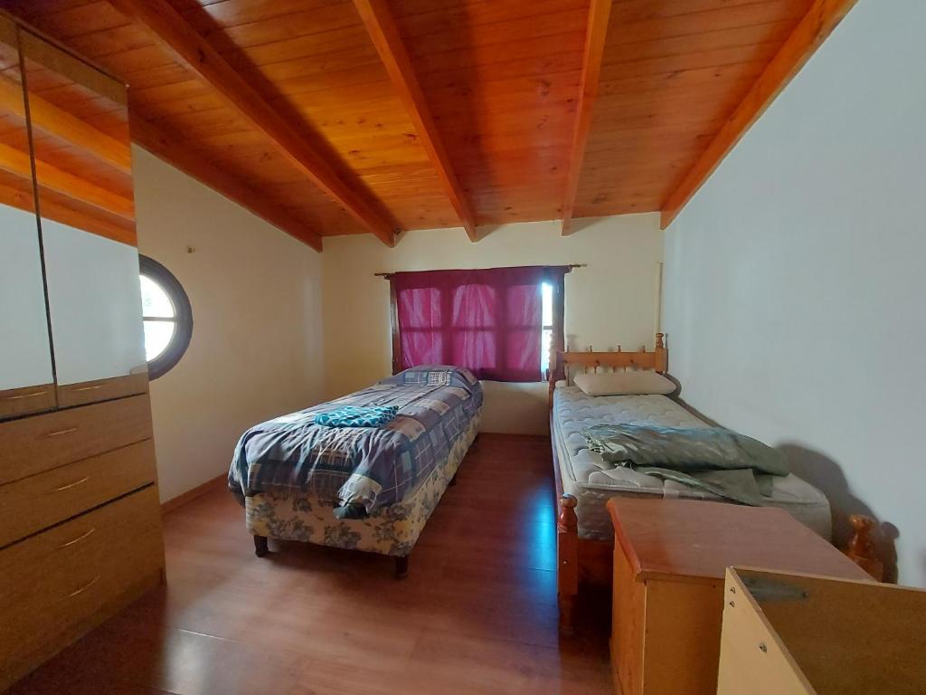 sypialnia z 2 łóżkami, biurkiem i oknem w obiekcie ButaCoin2 w mieście Buta Ranquil