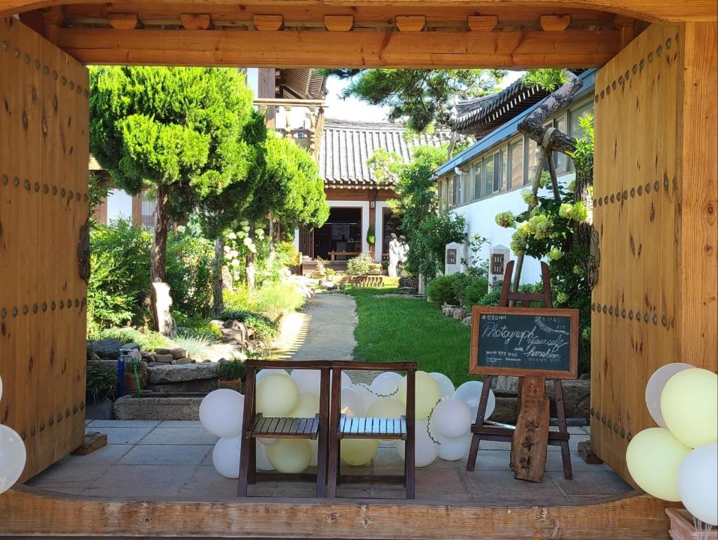 un cenador con sillas y una pizarra en un patio en HanokInn en Gyeongju