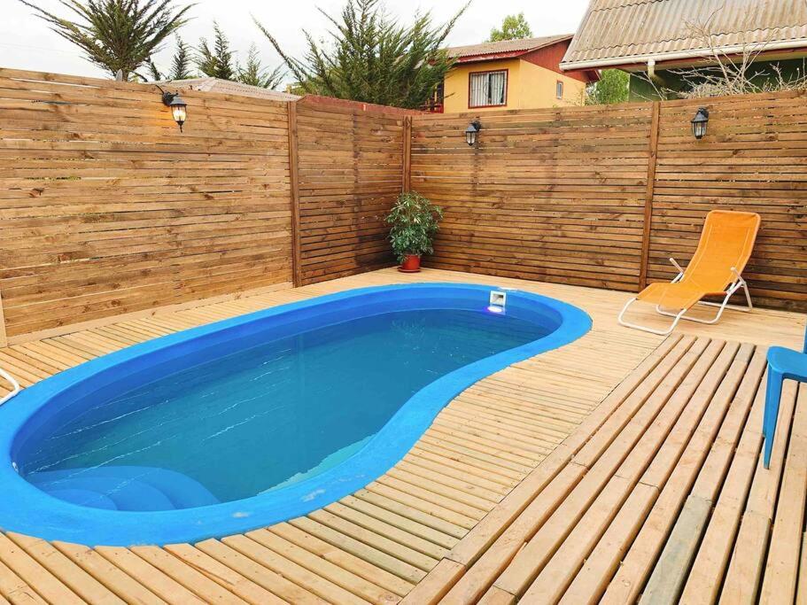 una piscina su una terrazza in legno con recinzione in legno di Hermosa Cábaña algarrobo a pasos de la playa ad Algarrobo