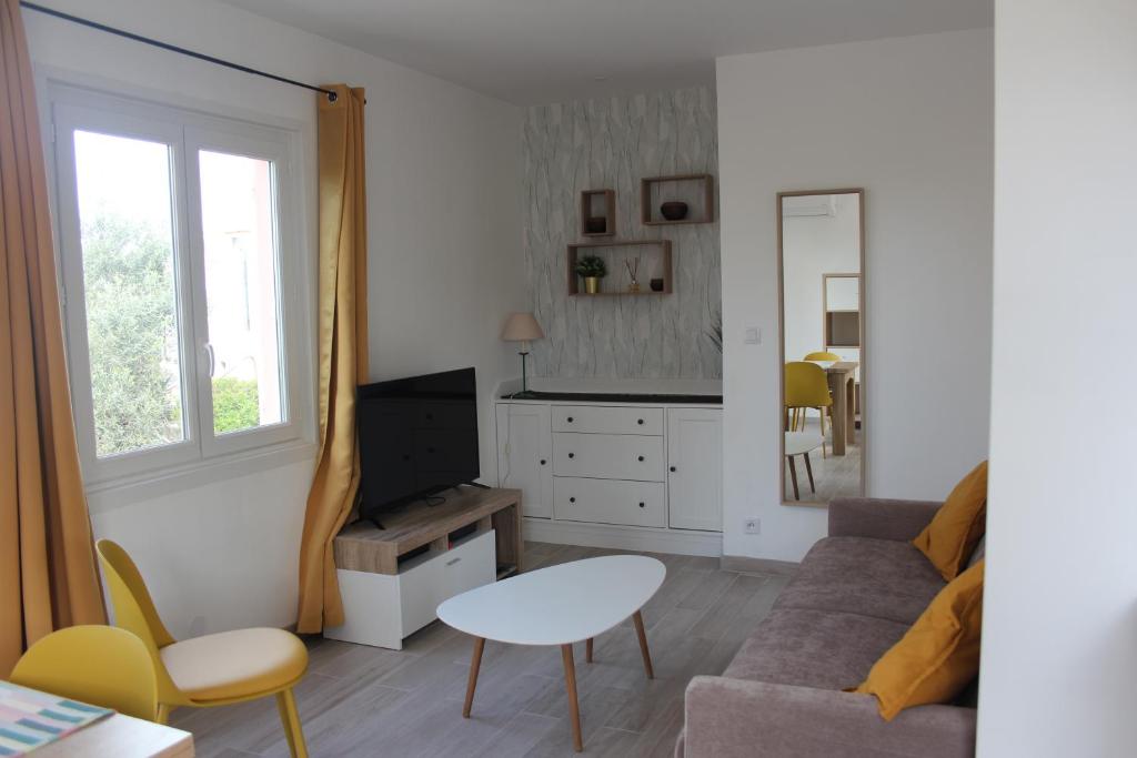 salon z kanapą i stołem w obiekcie Le Beau site by Beds83 w Fréjus