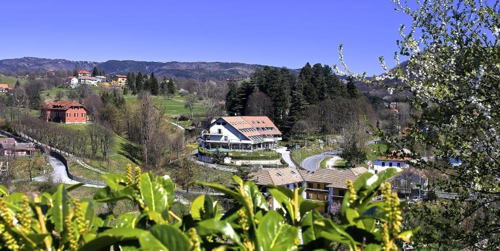 una casa in cima a una collina con una casa di Hotel Pian del Sole a Sassello