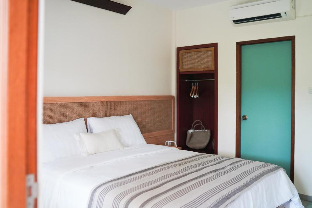 Postel nebo postele na pokoji v ubytování Roots Hotel Senggigi