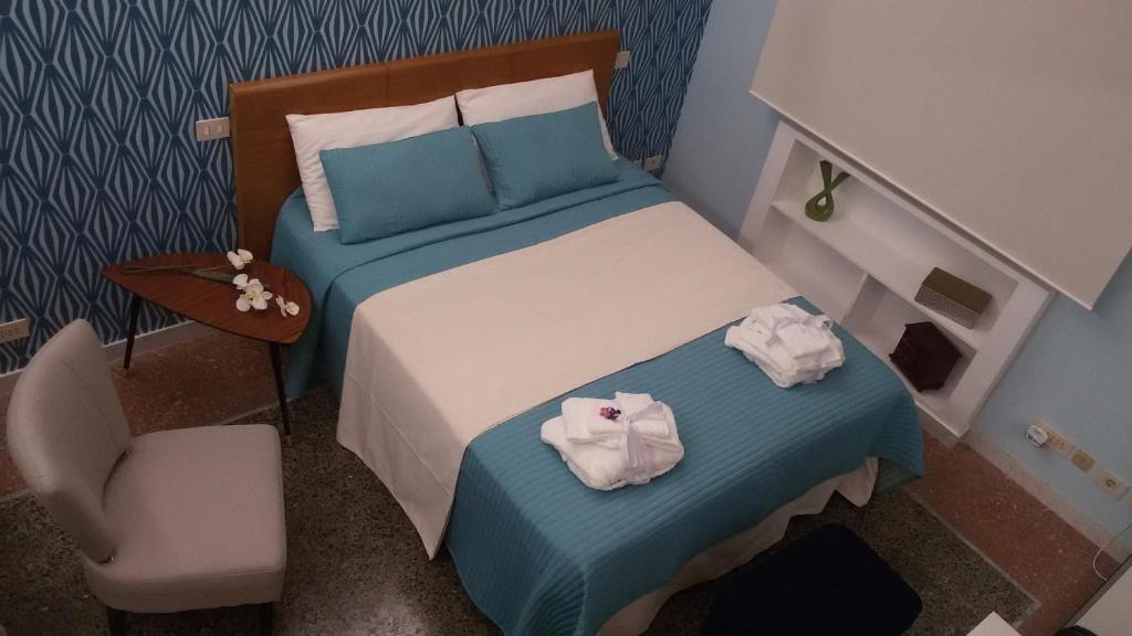 ローマにあるAd Vatican Suitesの小さなベッドルーム(ベッド1台、椅子付)