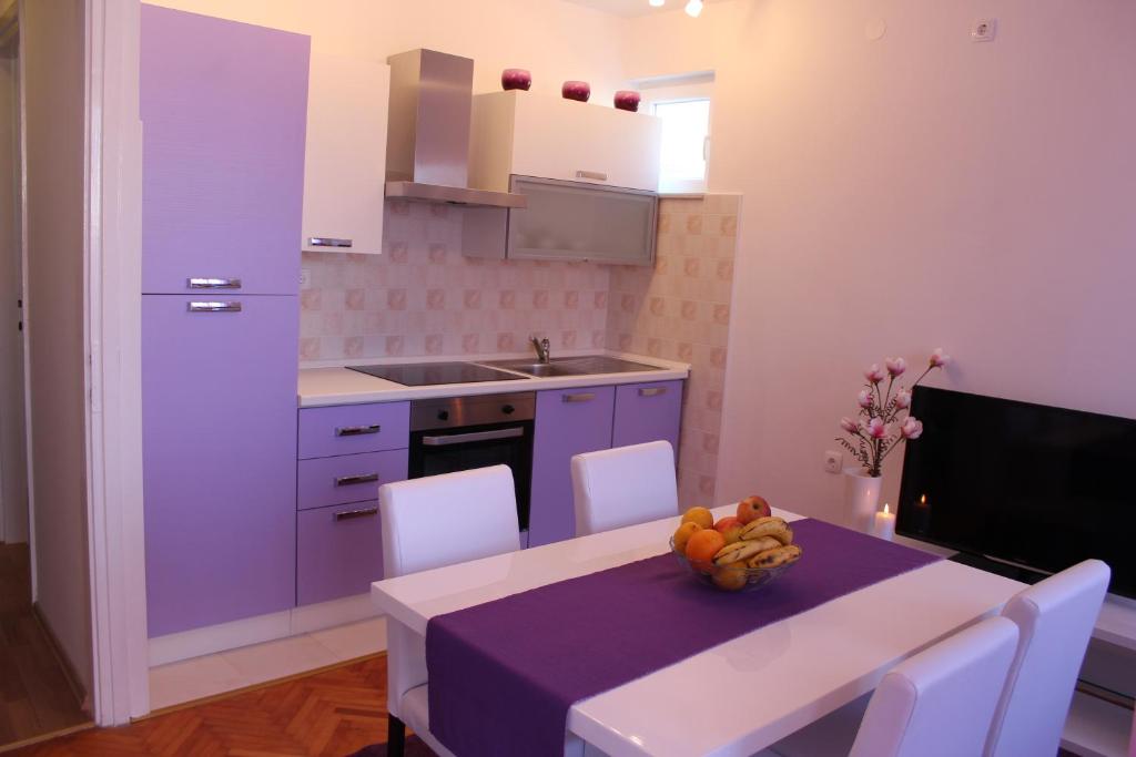 a kitchen with a table with a bowl of fruit on it at Great apartment Katarina in Zadar