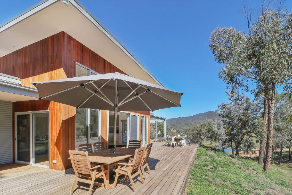 a wooden deck with a table and chairs and an umbrella at High Country Lodge in Mansfield