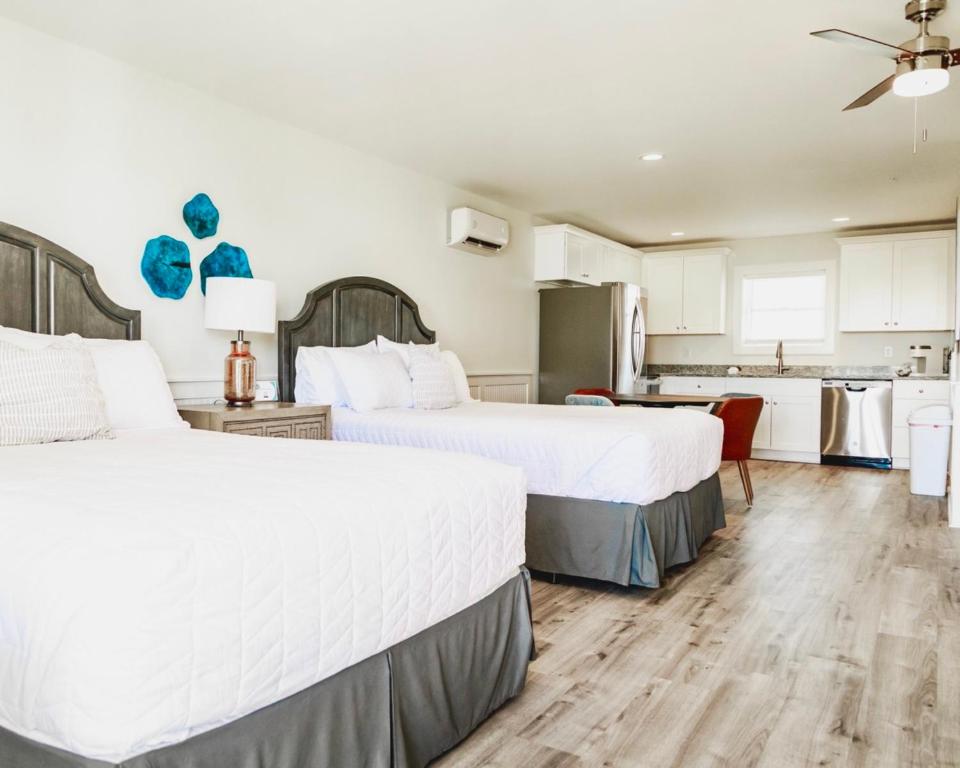 two beds in a hotel room with a kitchen at Saltwater 202 2nd Floor Low Tide in Surf City