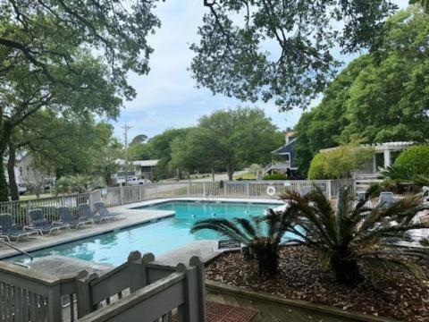 默特爾海灘的住宿－Sea Grove Condo，庭院内的游泳池,带椅子和树木