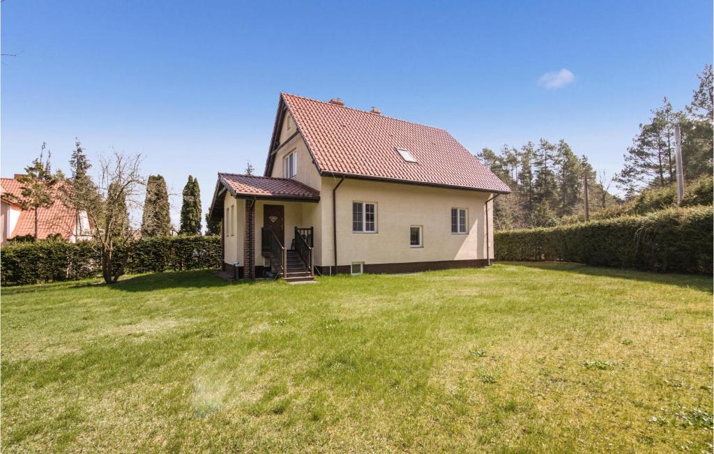 a small white house with a grass yard at Beautiful Home In Bogaczewo With 3 Bedrooms in Bogaczewo