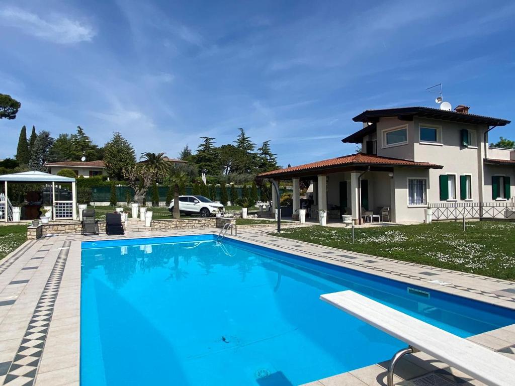 une grande piscine bleue devant une maison dans l'établissement La Dolce Vita - Private Villa with Pool, à Moniga del Garda