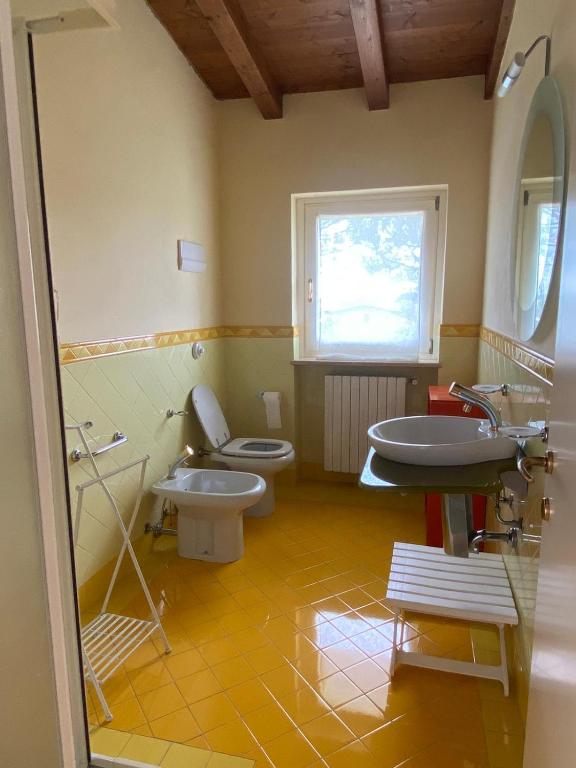 La salle de bains est pourvue de 2 toilettes, d'un lavabo et d'une fenêtre. dans l'établissement La Dolce Vita - Private Villa with Pool, à Moniga del Garda
