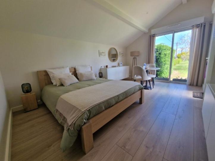1 dormitorio con cama grande y ventana grande en La Palentine, en Châteaumeillant
