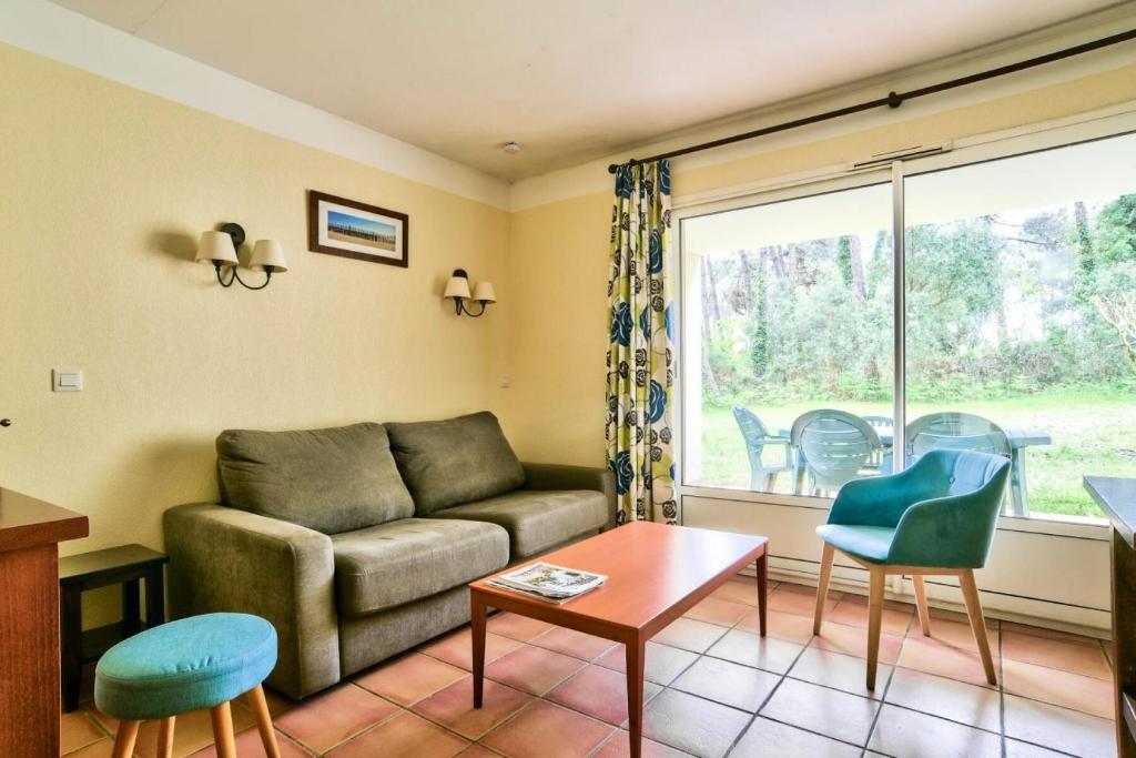 un salon avec un canapé et une fenêtre dans l'établissement Le Domaine du Golf de Pinsolle - maeva Home - Appartement 2 pièces 6 personnes - Prestige MAE-7084, à Soustons