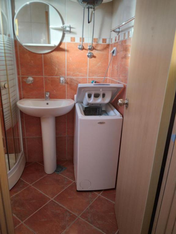 ein kleines Bad mit einem Waschbecken, einem WC und einem Waschbecken in der Unterkunft Apartments Mitrović Podličak in Sveti Stefan