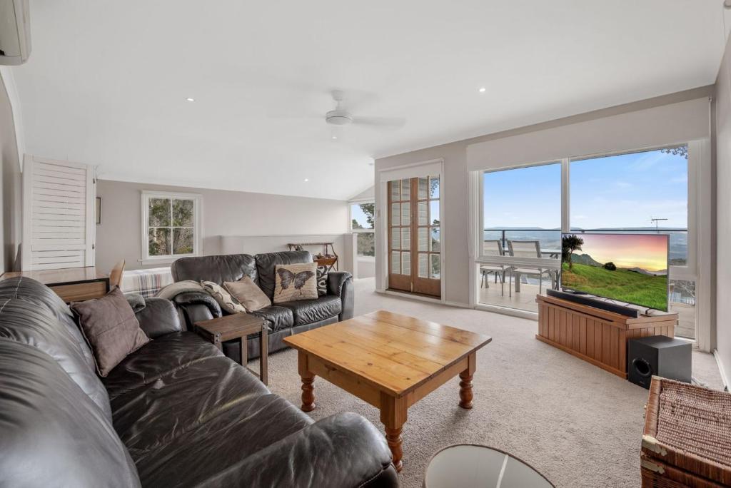 una sala de estar con un sofá y una mesa en Currawong, en Blackheath