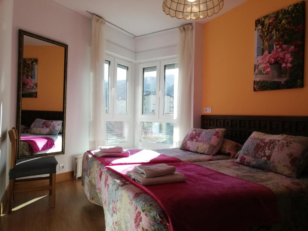 um quarto com uma cama, um espelho e janelas em Apartamento Peñalabra em Potes