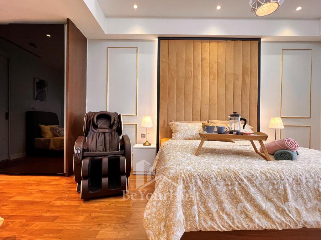 a bedroom with a large bed and a table at Anggun Residences Luxury Suites KL City Center in Kuala Lumpur