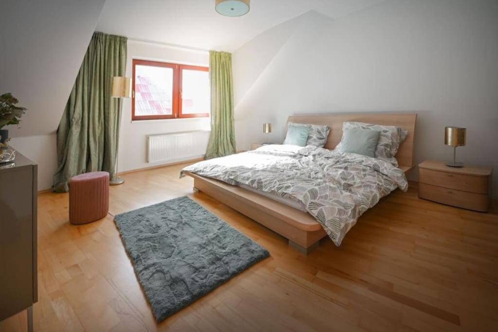 sypialnia z łóżkiem z zielonymi zasłonami i dywanem w obiekcie V CENTRU dění w Ołomuńcu