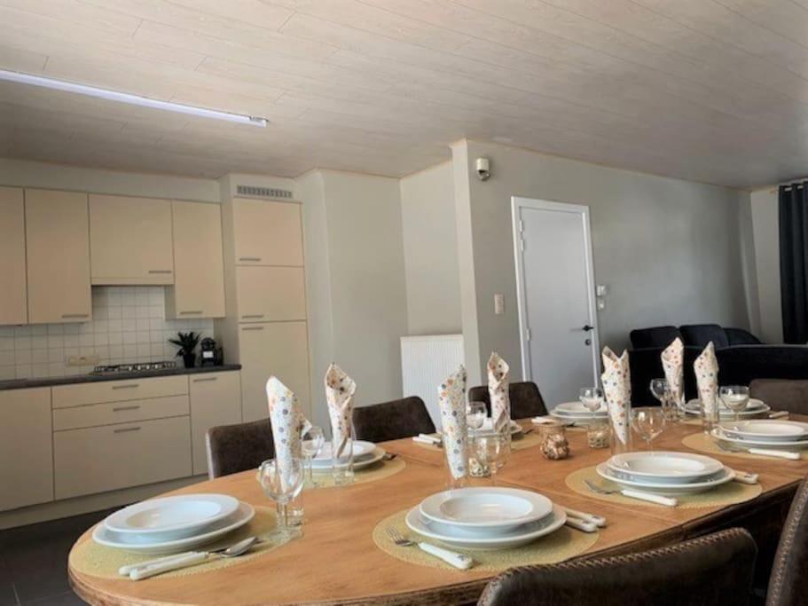 a dining room table with plates and dishes on it at Raversea op enkele minuten wandelen van de zee. in Ostend