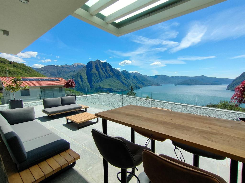 a patio with a table and chairs and a view of a lake at IseoLakeRental - Blue Note in Solto Collina