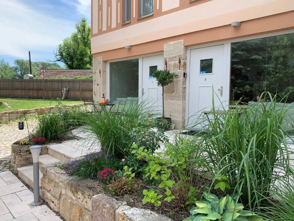 einen Garten vor einem Haus mit Pflanzen in der Unterkunft Ferienwohnung "Alte Mühle" in Jena