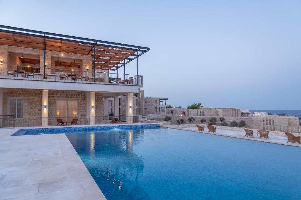 une grande piscine en face d'un bâtiment dans l'établissement Wadi Sabarah Lodge, à Marsa Alam