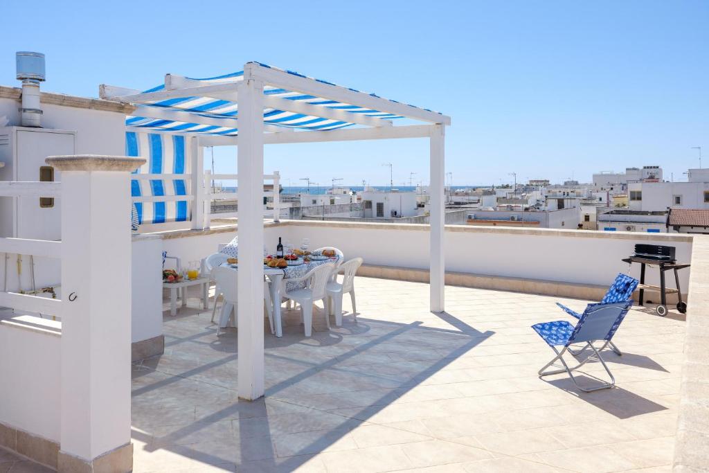 eine Terrasse mit einem Tisch und Stühlen auf dem Dach in der Unterkunft Residenza Acquamarina Vista Mare in Porto Cesareo