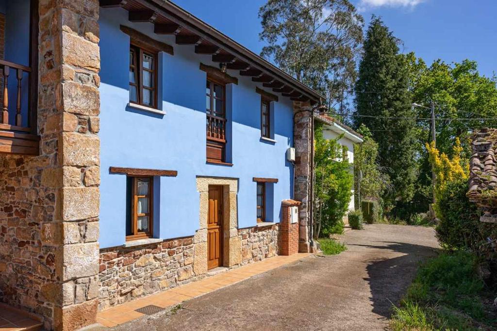 een wit huis met houten ramen en een straat bij Apartamento Rural Celada 2 