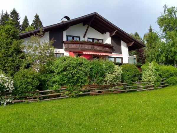 ein Haus mit einem Balkon auf einem grünen Feld in der Unterkunft Haus Schwärzler - Säntisblick in Sulzberg