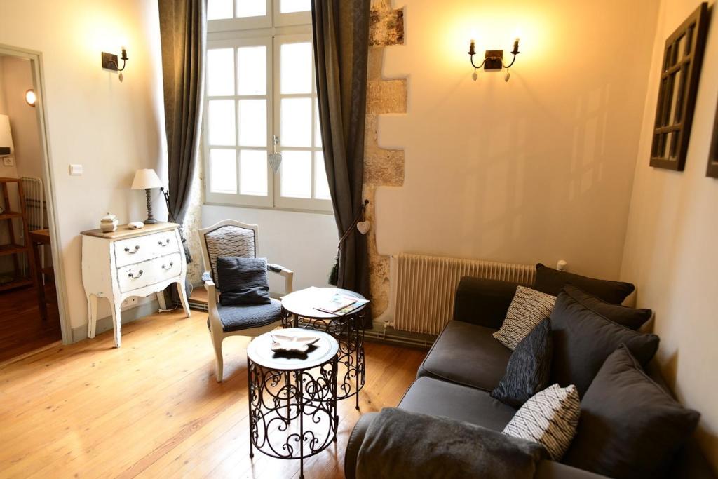 een woonkamer met een bank en een stoel bij Truffle in Sarlat-la-Canéda